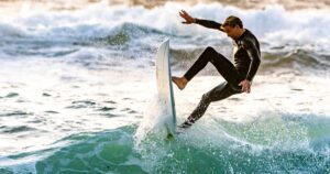 Surfer im Neoprenanzug fährt einen vertikalen Turn in der Welle 2026 — Sinnbild für Yago Doras perfekte 10 am Manu Bay in Raglan