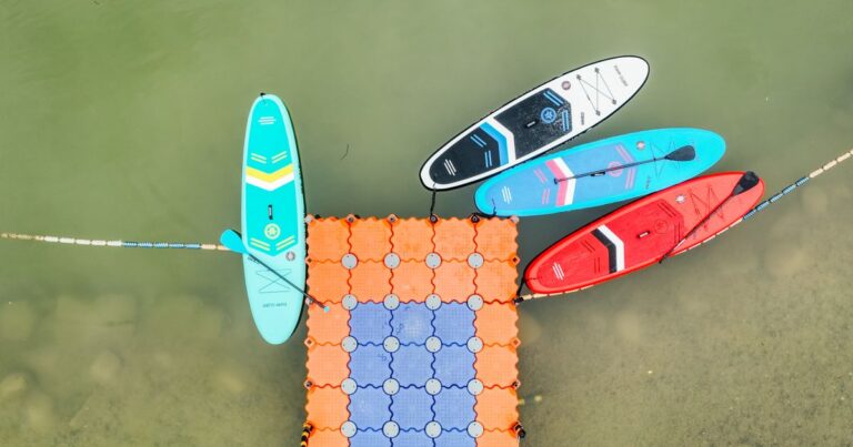 Vier Stand-up-Paddleboards mit Paddeln von oben auf einem Steg — Symbolbild fuer SUP-Gear-Trends 2026
