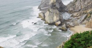 Atlantikwellen brechen an nebliger Steilkueste in Portugal - Symbolbild zum El-Nino-Surf-Winter 2026/27 in Europa