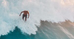 Surfer in warmer blauer Welle — Symbolbild zum Fiji Pro 2026 in Cloudbreak, Fidschi